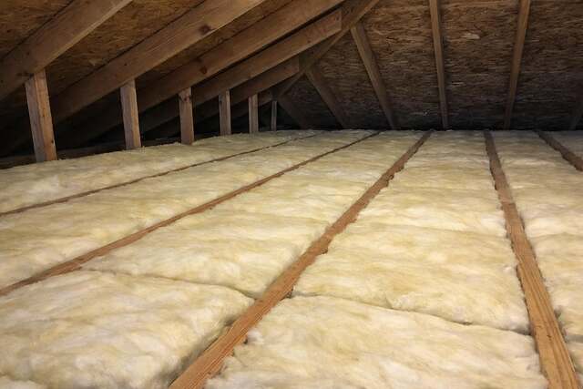 Fresh insulation batts laid between attic joists