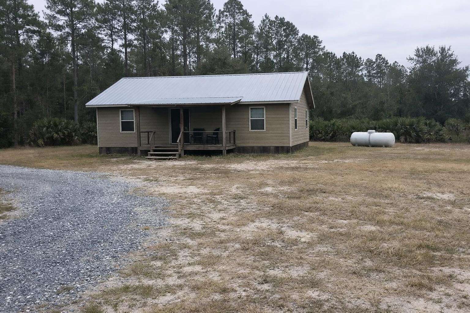 A wood-frame house on a large wooded lot