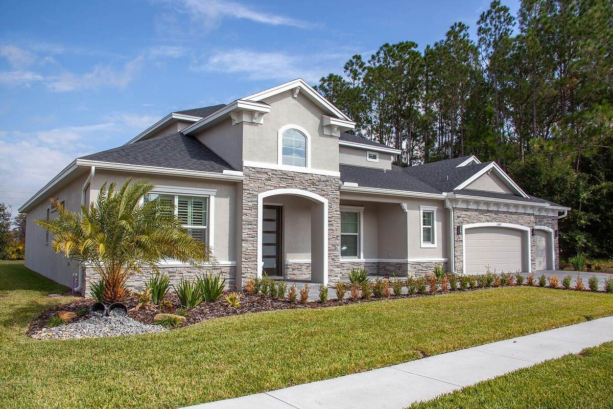 A two-story stucco house with a two-car garage and driveway